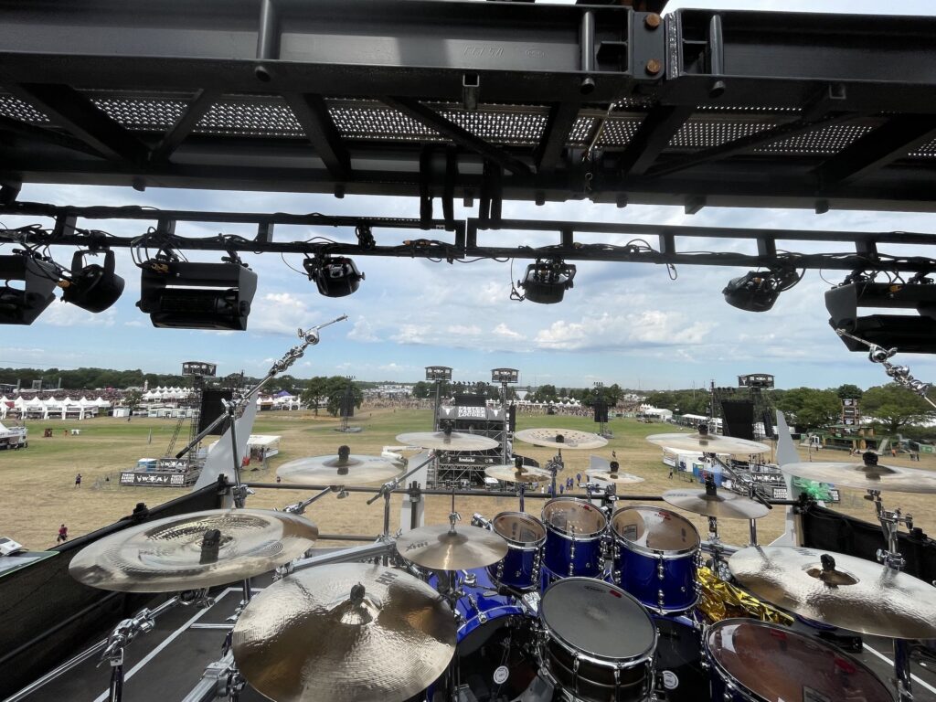 Bild von Bühne des Wacken Open Air Festival zum Festivalgelände hin. Im vOrdergrund ist ein Schlagzug zu sehen.